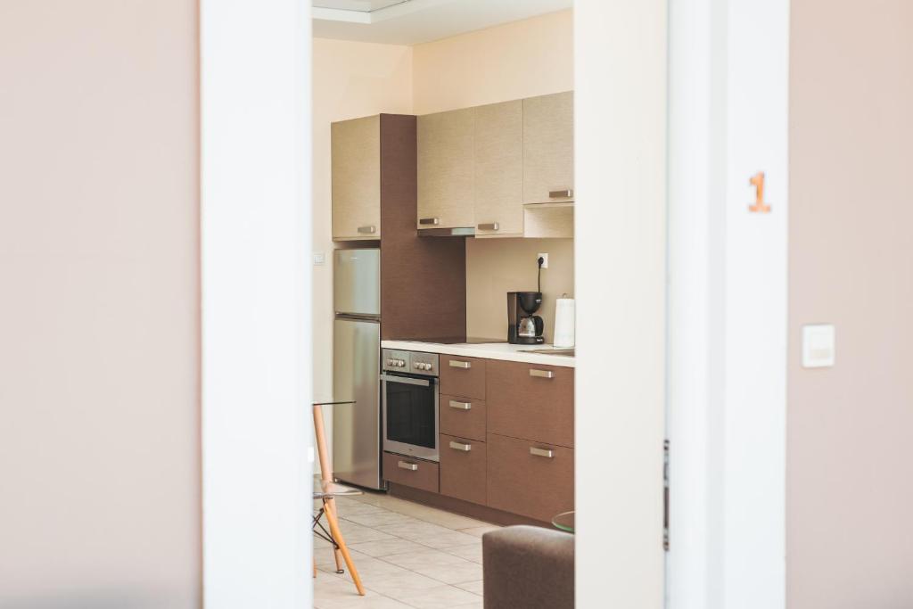 a kitchen with brown cabinets and a stove top oven at Plakoures Home in Kounoupidhianá