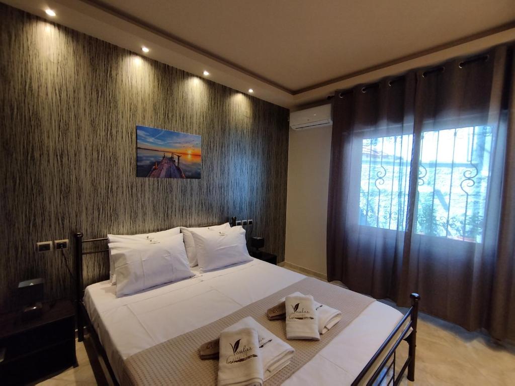 een slaapkamer met een groot bed en handdoeken bij Voulas Guest House in Volos