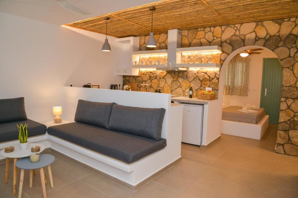 a living room with a couch and a kitchen at Mylopetra Milos Suites in Tripití