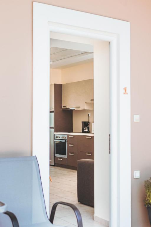 an open door into a kitchen with a couch at Plakoures Home in Kounoupidhianá
