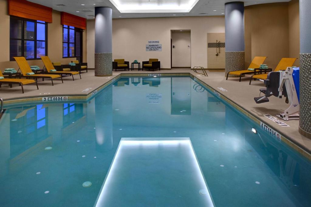 迪凱特的住宿－亞特蘭大迪凱特市中心/埃默里萬怡酒店，酒店客房的大型游泳池配有椅子