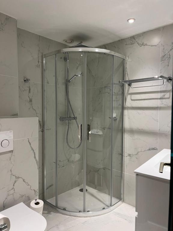 um chuveiro com uma porta de vidro na casa de banho em Hôtel Cannes Centre Univers em Cannes