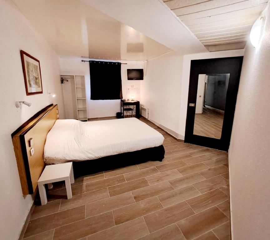 a bedroom with a bed and a mirror in it at Crystal Hotel Saint Denis Basilique in Saint-Denis