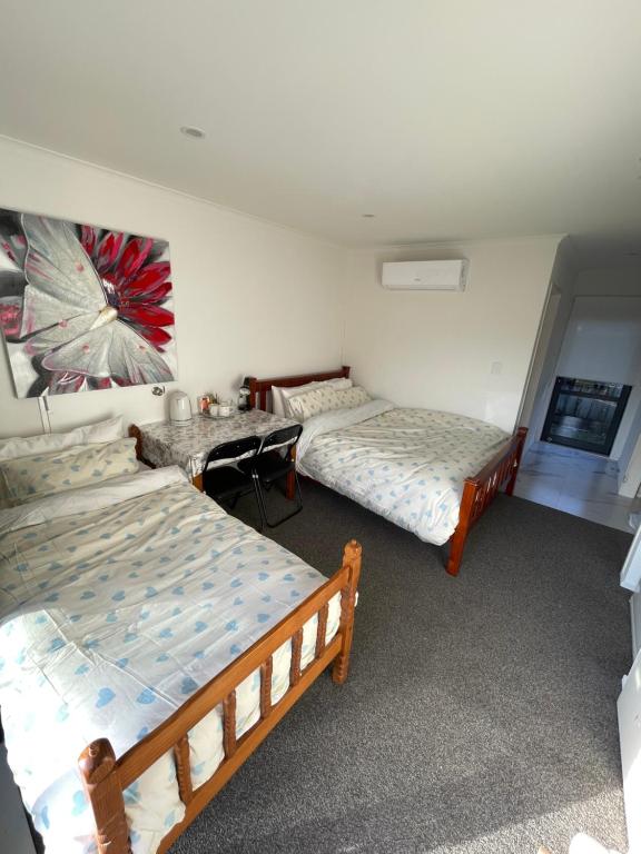 a room with two beds and a table in it at Sunny self checkin studio with private entry& ensuite&heat pump in Hamilton