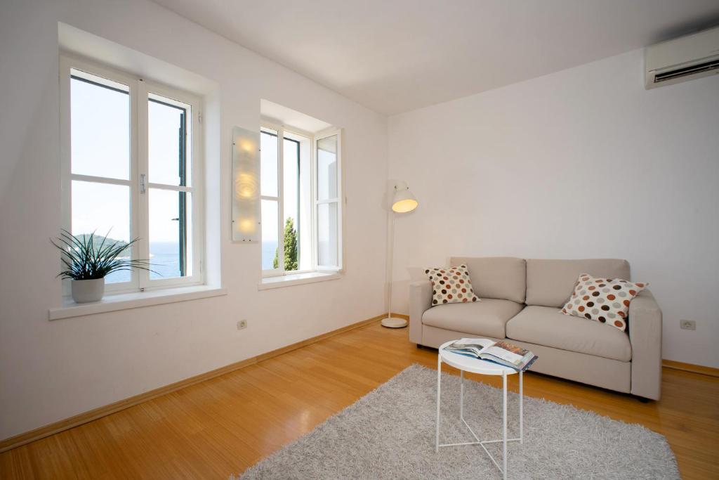 a living room with a couch and two windows at Apartment St.Jacob in Dubrovnik