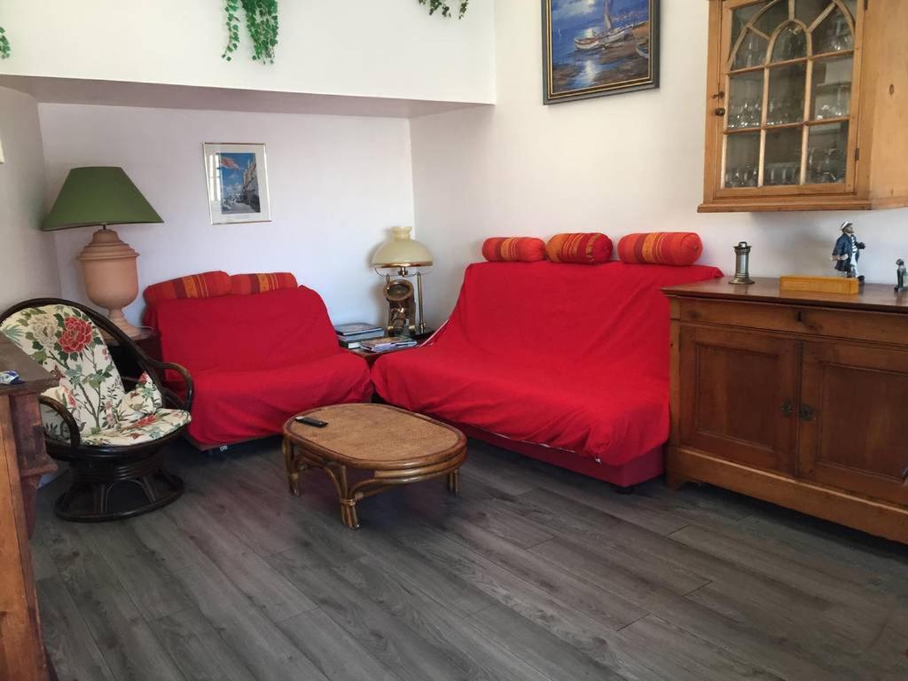 un salon avec deux canapés rouges et une table dans l'établissement Appartement Deauville Marina 6 personnes, à Deauville