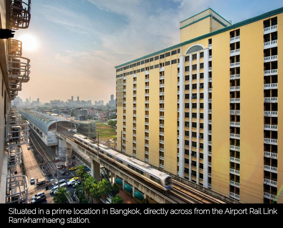 Nasa Bangkok - SHA PLUS Certified في بانكوك: مبنى اصفر طويل امامه قطار