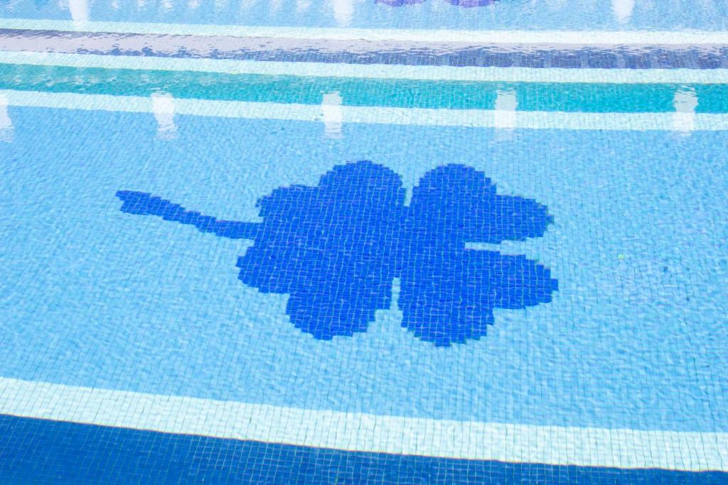 a blue picture of a plant in a swimming pool at Hotel Hacienda Montenmedio in Vejer de la Frontera