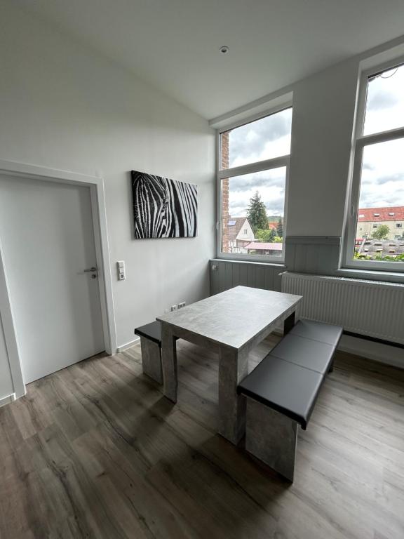 une chambre avec une table, un banc et deux fenêtres dans l'établissement Alte Schule 1, à Schauenburg