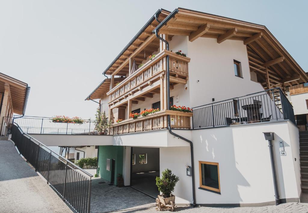 a white building with a balcony on top of it at Ragitt Stodl Ferienwohnungen in Vols am Schlern