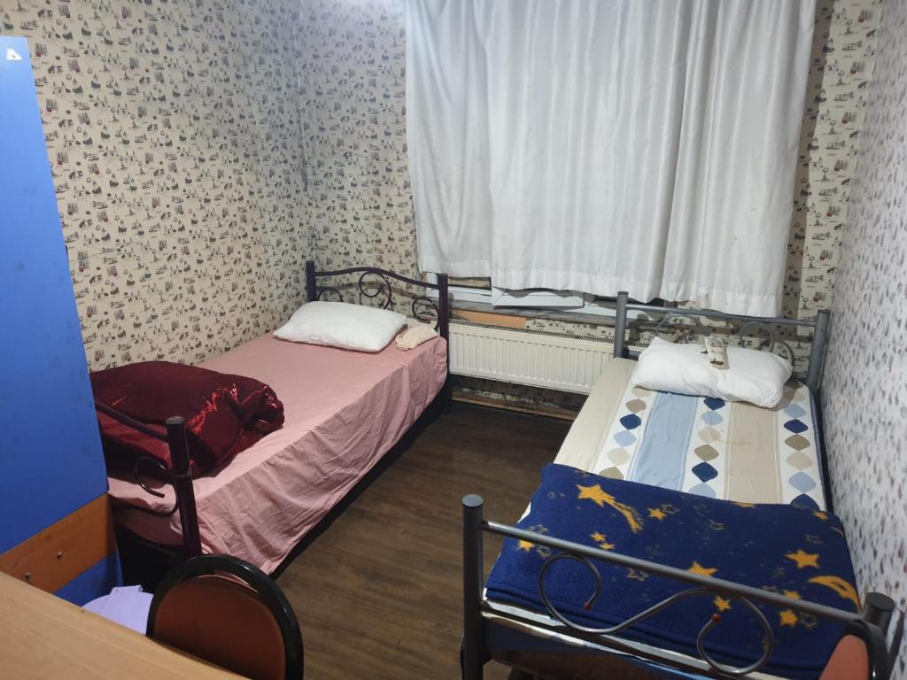 a small room with two beds and a window at Men's Hostel in Fatih, Istanbul in Istanbul