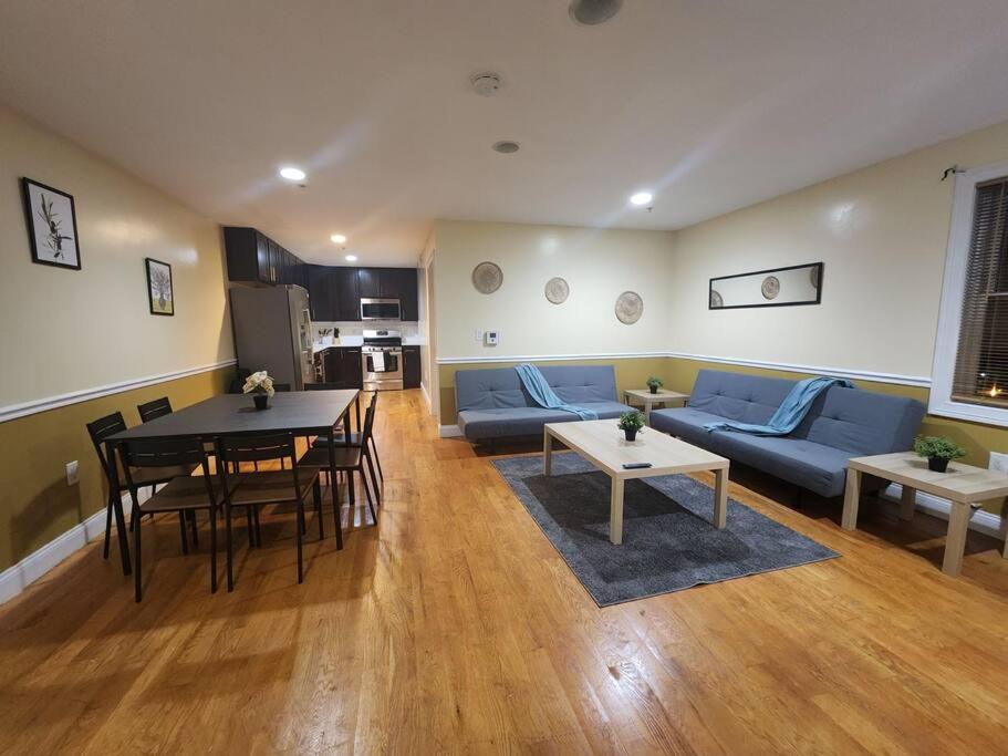 a living room with a blue couch and a table at Classy 3 bed near NYC with view! in Union City