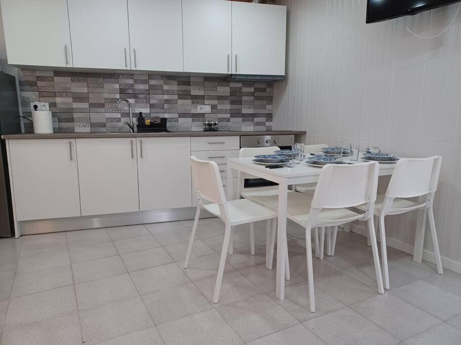a kitchen with a white table and white chairs at AL Boca da Canada in Água de Alto