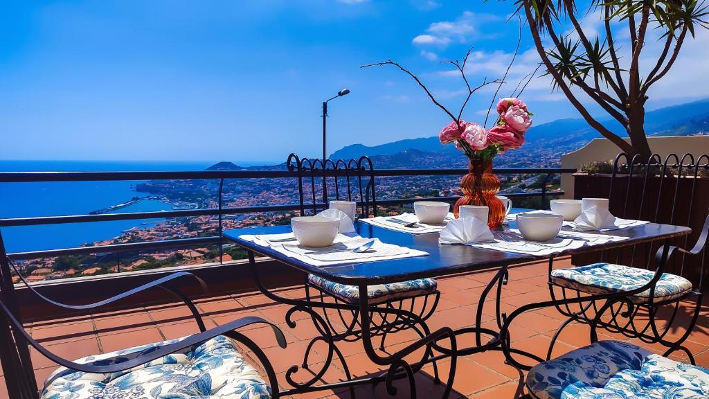 un tavolo e sedie su un balcone con vista di Casa Gina, with views to Funchal Bay a Funchal