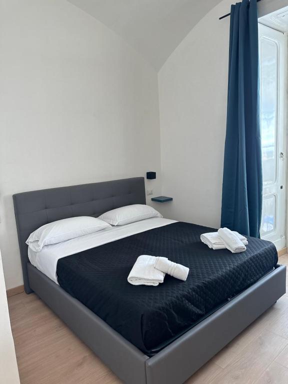 ein Bett mit zwei weißen Handtüchern darüber in der Unterkunft Maison Dante in Neapel
