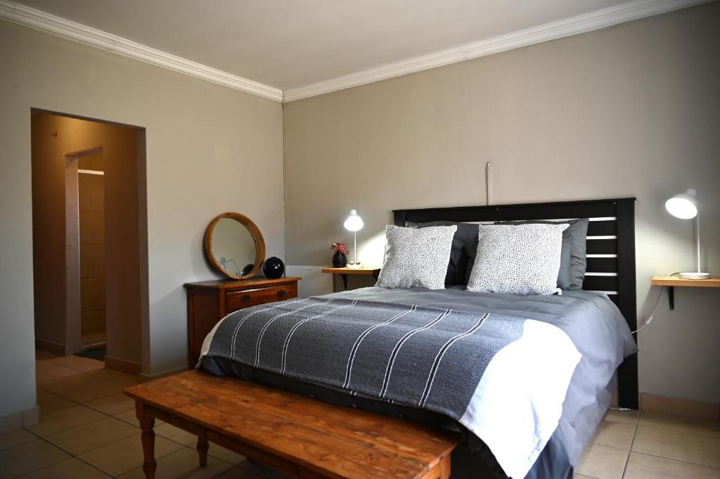 sypialnia z łóżkiem z drewnianym stołem i lustrem w obiekcie Summersun Village w mieście Parys