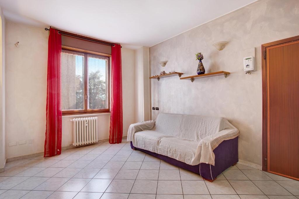 a bedroom with a bed and a window with red curtains at Easy Home vicino a Milano e Monza in Nova Milanese