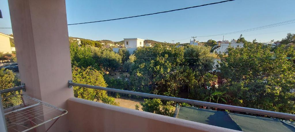 a balcony with a view of trees and buildings at Billy's apartments in Artemida