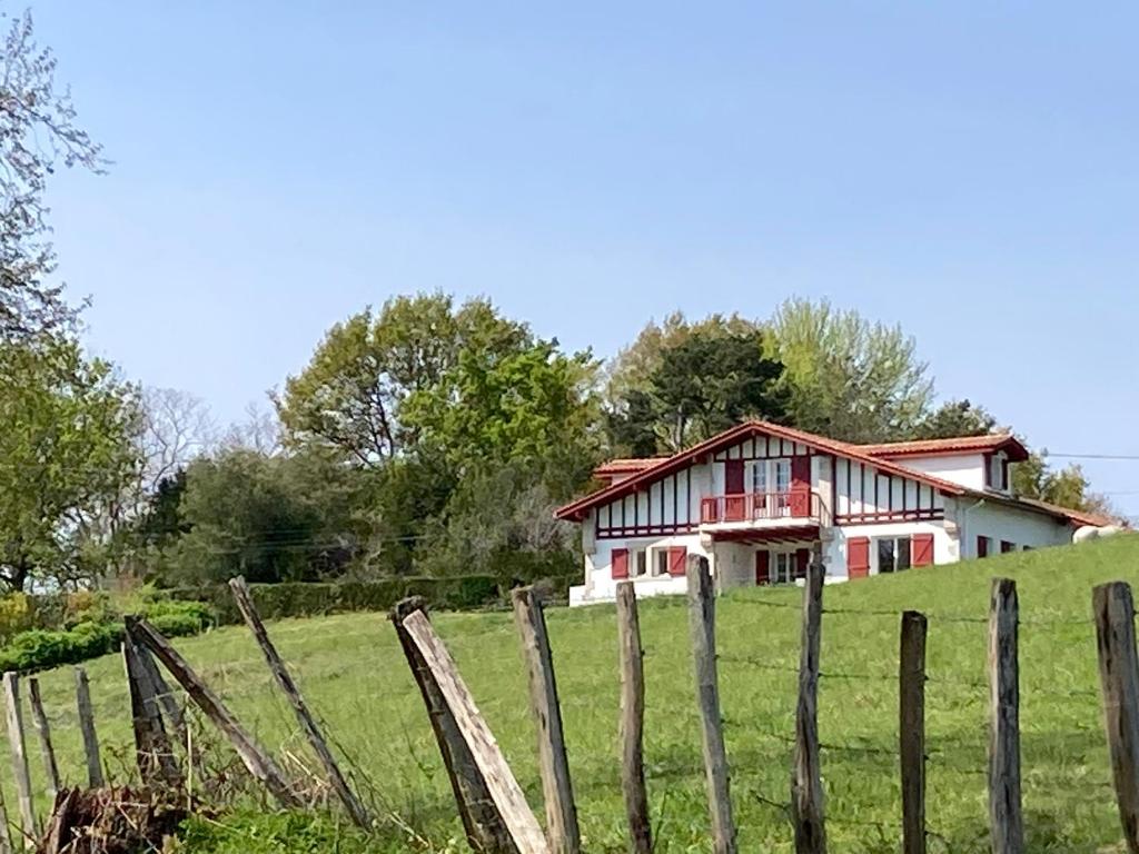 a house on a hill behind a fence at Maison dans la Prairie in Bidart