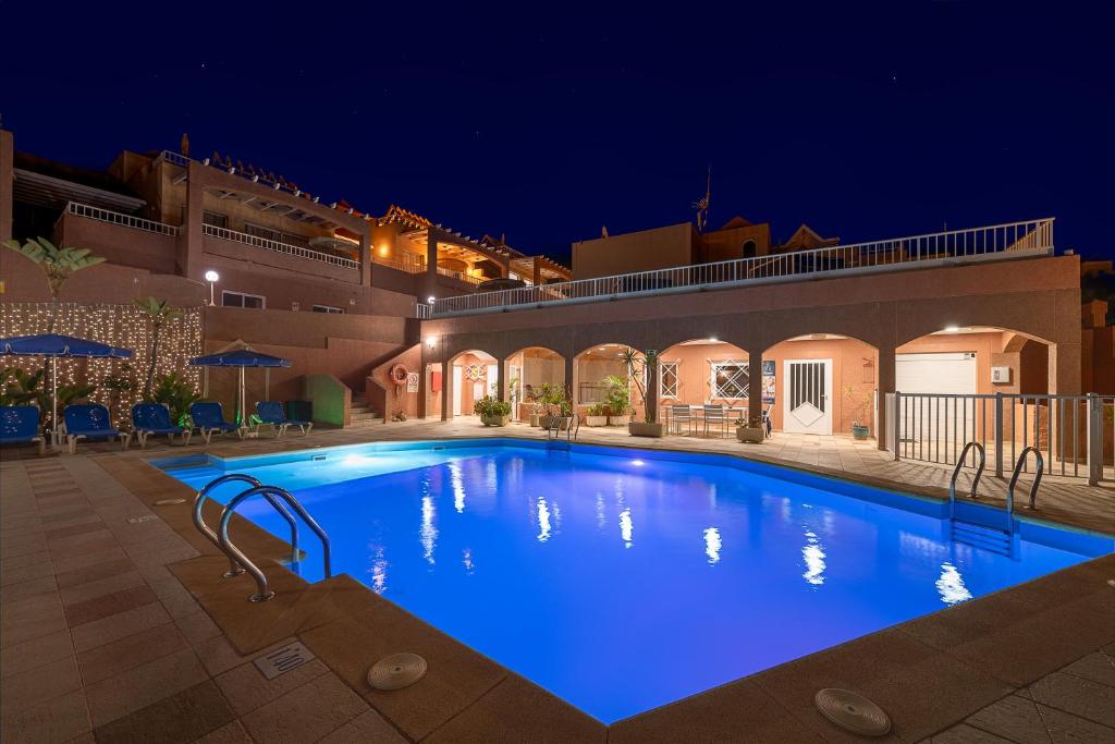 a large blue swimming pool at night at Villas Monte Solana in Morro del Jable