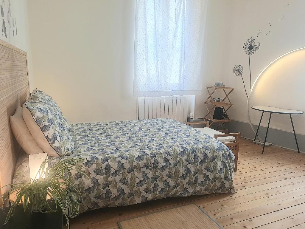 a bedroom with a bed and a table and a window at Chambre indépendante in Die