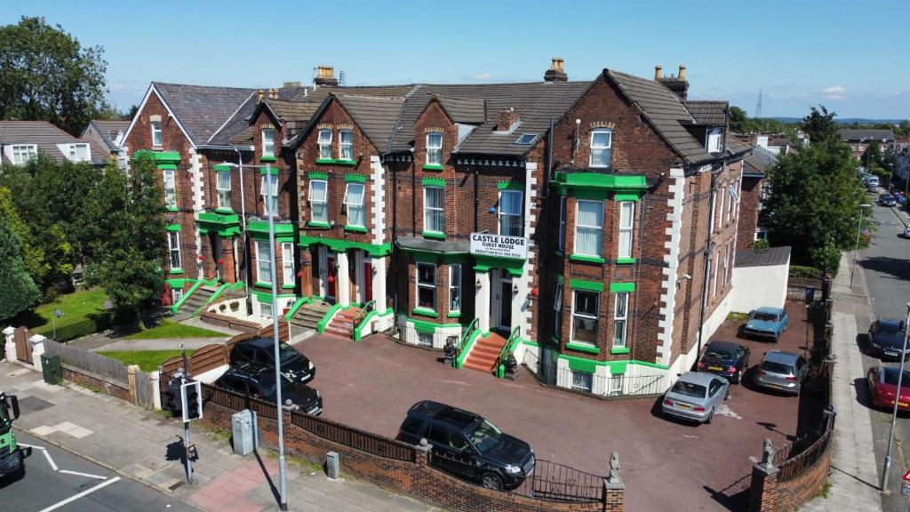 un edificio de apartamentos con coches aparcados en un aparcamiento en Castle Lodge Guest House 86-88 Sheil Rd L6 3AF en Liverpool