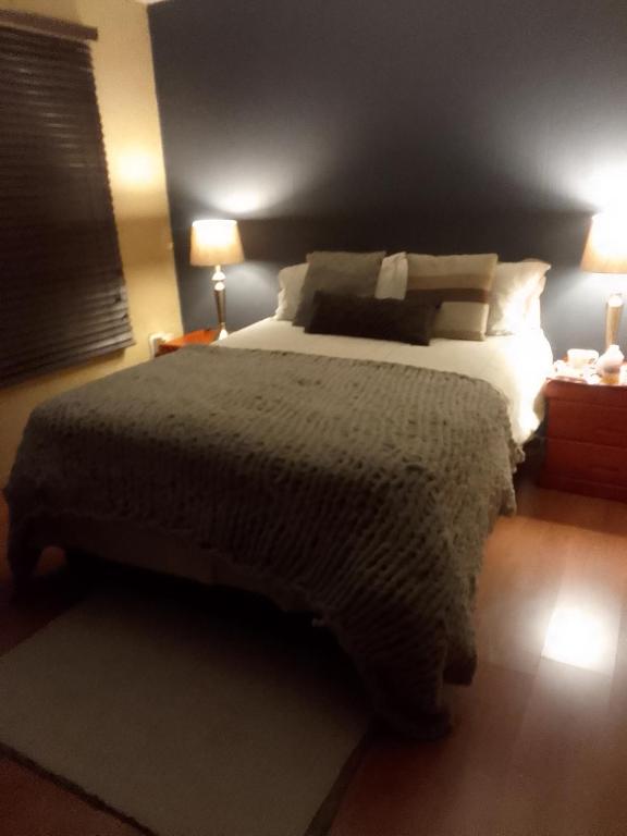 a bedroom with a large bed and two lamps at Room2rent Centurion in Pretoria