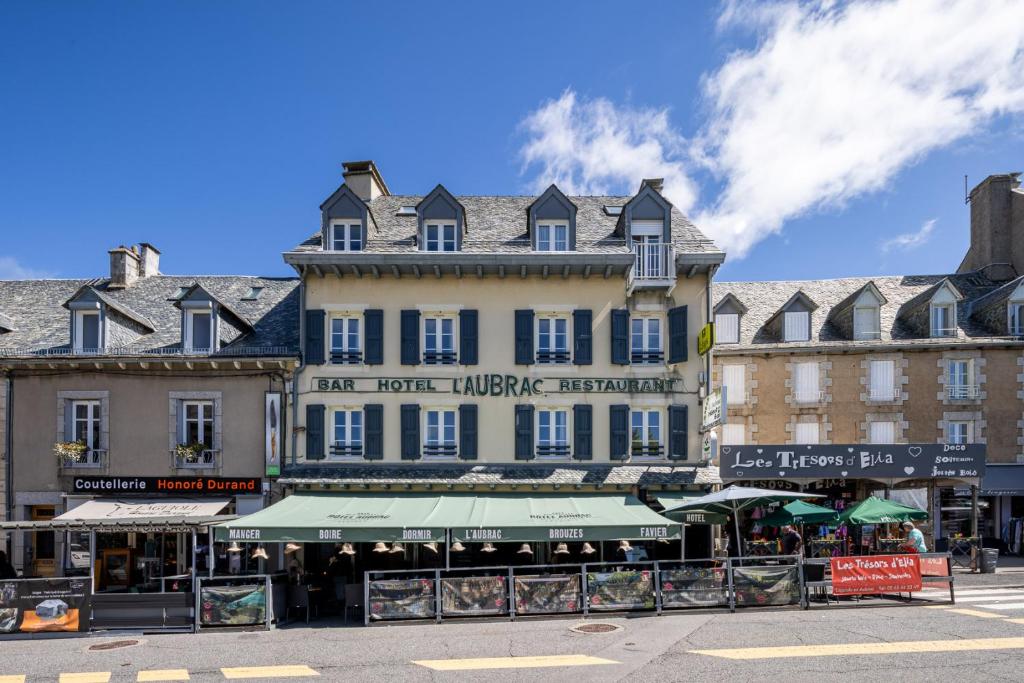 a large building in the middle of a street at Hôtel-Restaurant Logis l'Aubrac Laguiole in Laguiole