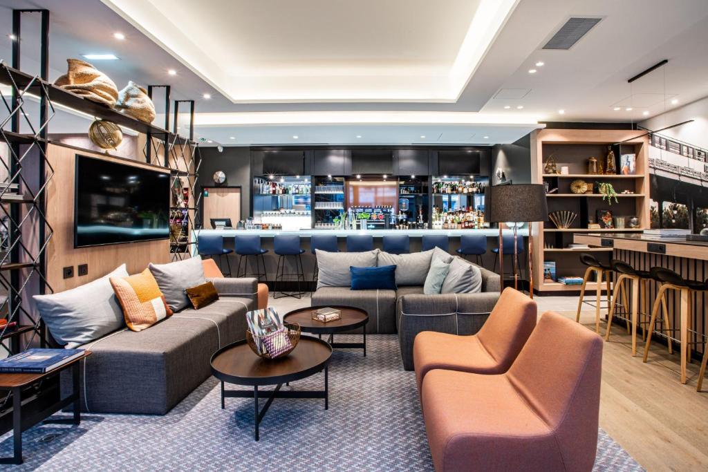 a hotel lobby with couches and a bar at Courtyard by Marriott Paris Porte de Versailles in Issy-les-Moulineaux