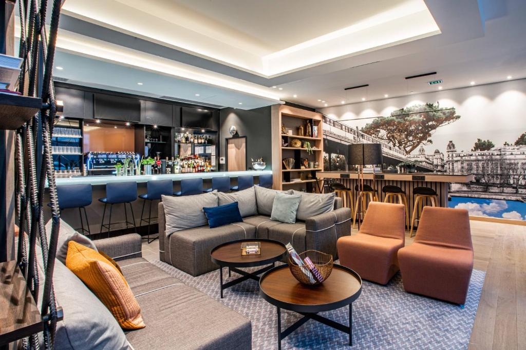 a lobby with a couch and a bar at Courtyard by Marriott Paris Porte de Versailles in Issy-les-Moulineaux