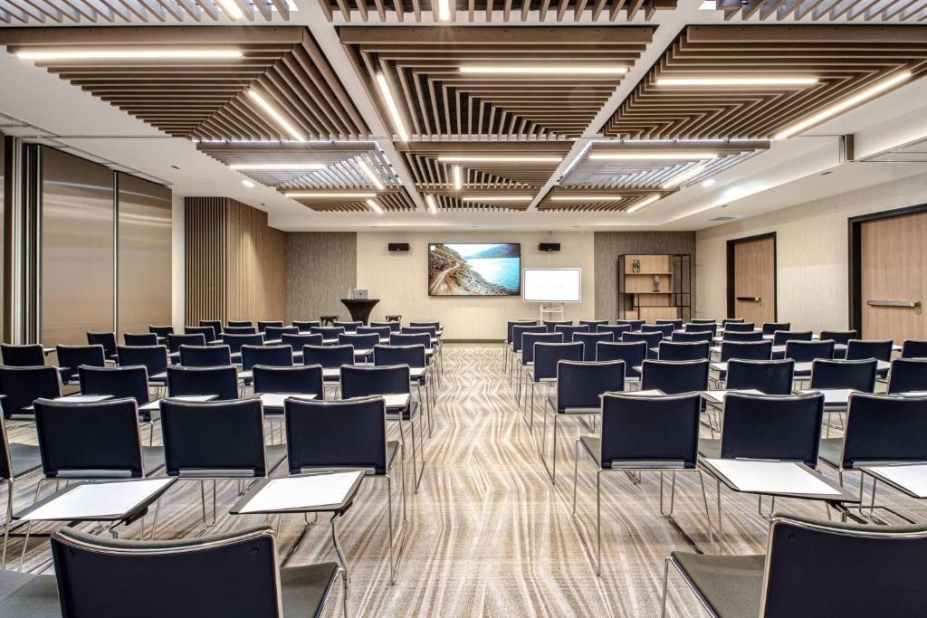 a conference room with chairs and a podium at Courtyard by Marriott Paris Porte de Versailles in Issy-les-Moulineaux