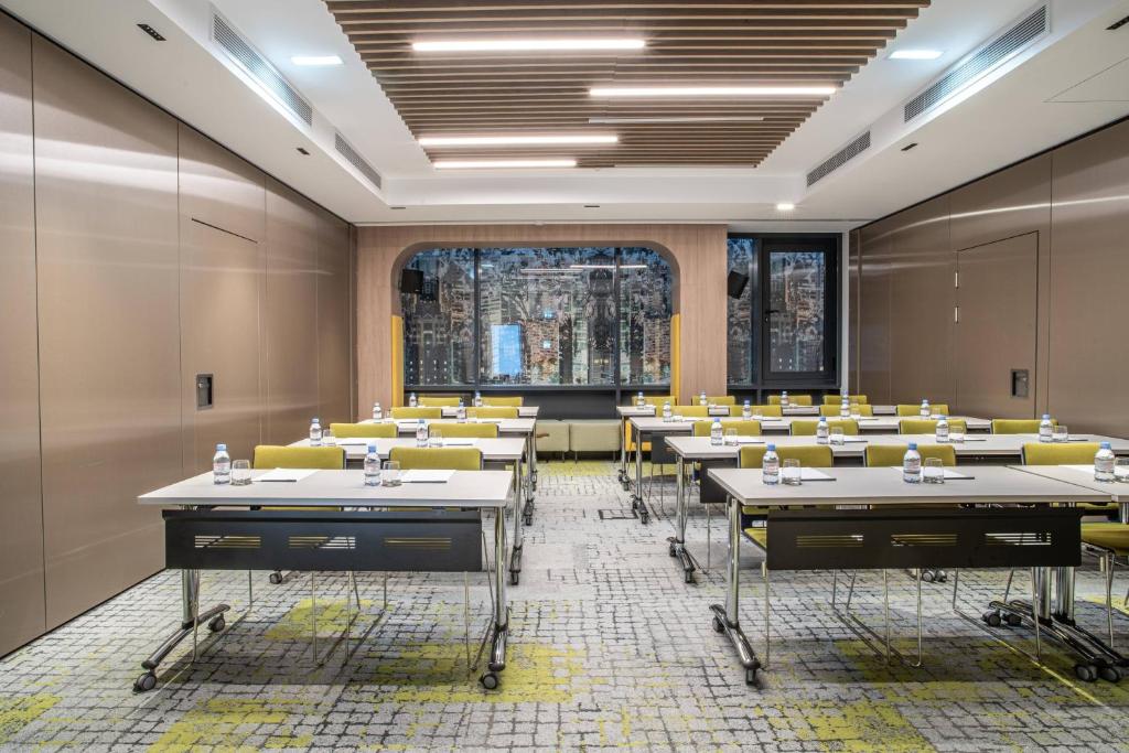 a conference room with tables and yellow chairs at Courtyard by Marriott Paris Porte de Versailles in Issy-les-Moulineaux