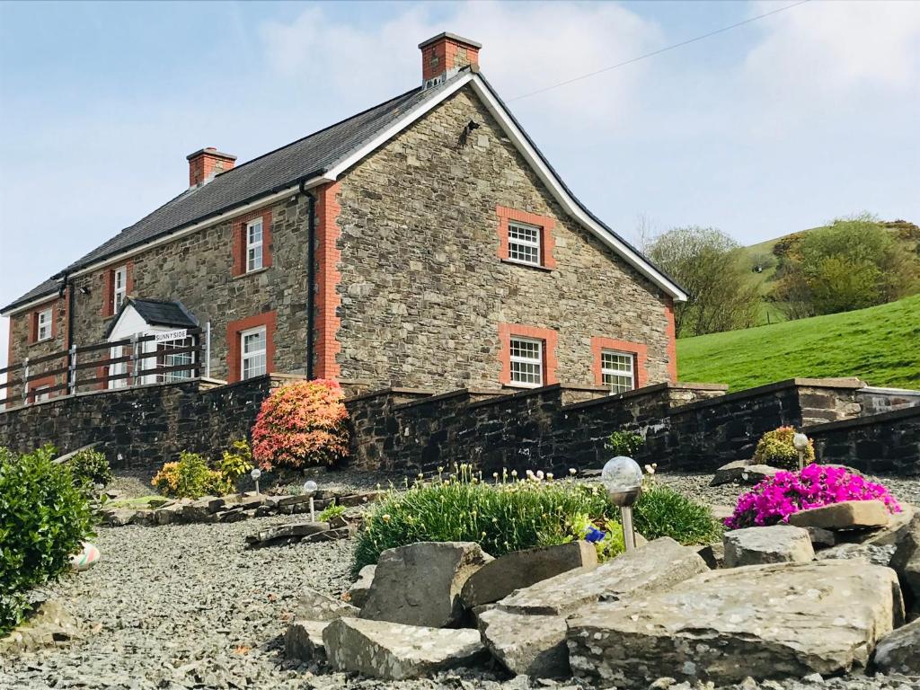 a stone house with a garden in front of it at Sunnyside hottub Brecon Beacons sleeps 8 in Lower Chapel