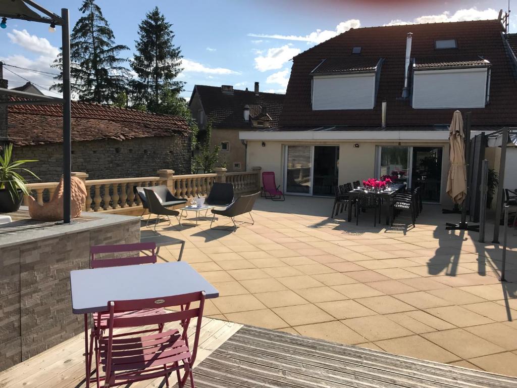 une terrasse avec des chaises et des tables ainsi qu'une maison dans l'établissement AU POINT DE VUE DE LA ROCHE, à Morey