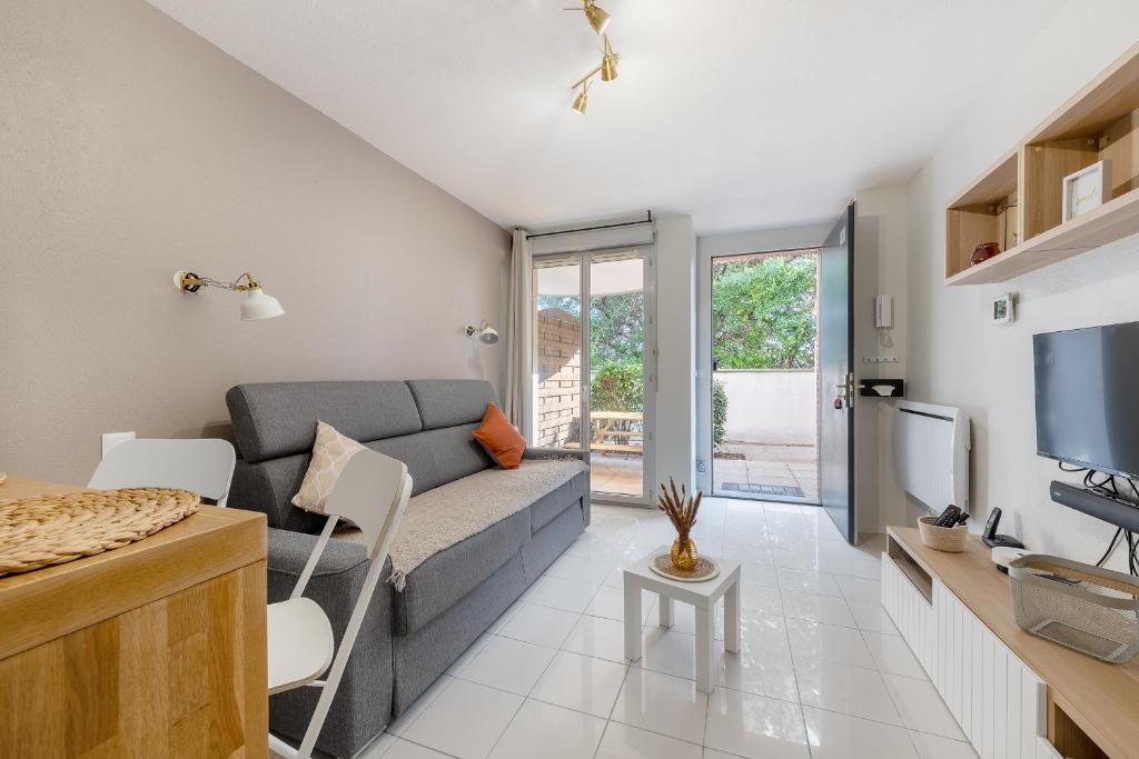 un salon avec un canapé et une télévision dans l'établissement Les Terrasses de Rangueil : studio avec parking, à Toulouse