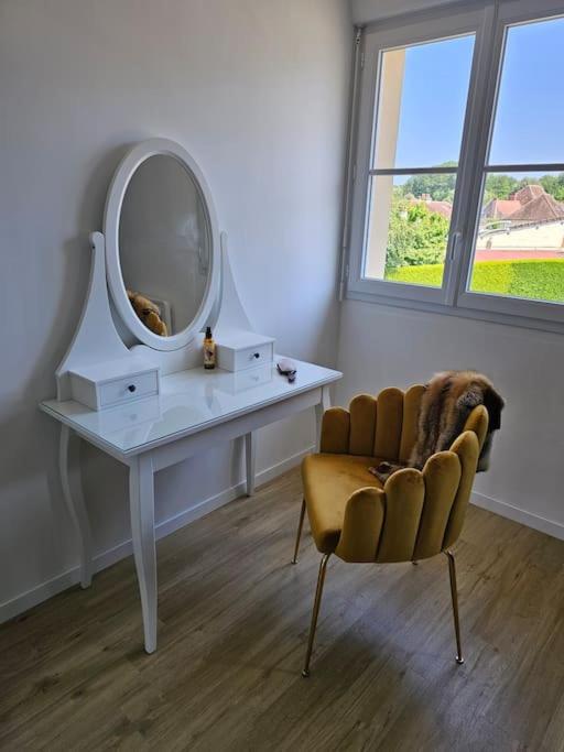 a room with a table and a chair and a mirror at Maison Le Bois Petit in Mouy