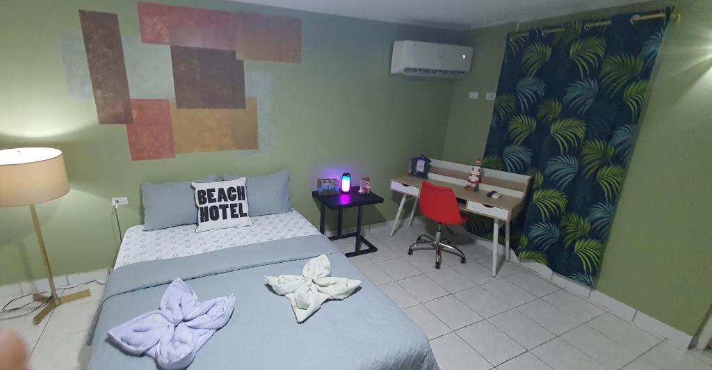 a bedroom with a bed and a desk and a desk at BUSHWA APARTMENTS #2 , Tu 5 estrellas in Oranjestad