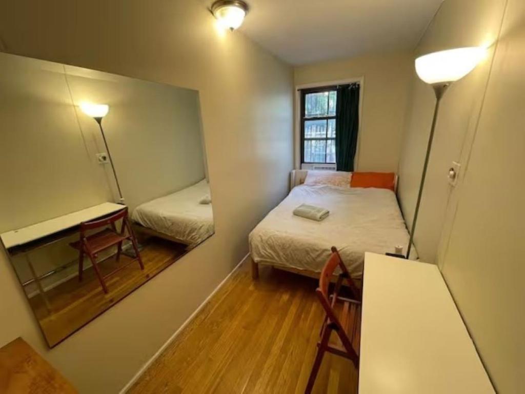 Central and Affordable Williamsburg Private bedroom Close to Subway في بروكلين: غرفة صغيرة بها سرير ومرآة