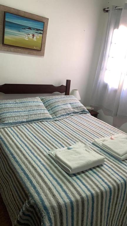 a bed with two towels sitting on top of it at villa in Petrópolis