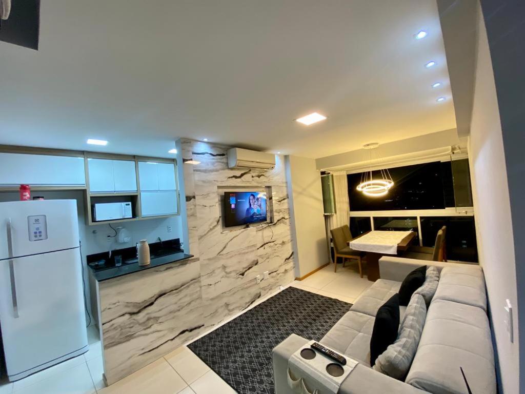 uma sala de estar com um sofá e uma televisão num quarto em Cobertura Duplex Encantadora com jacuzzi Privativa Vista mar em Vila Velha