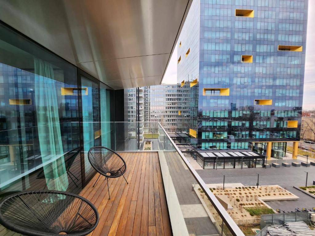 balcone con 2 sedie e vista su un edificio di One Apartment near Lake in Bucharest a Bucarest