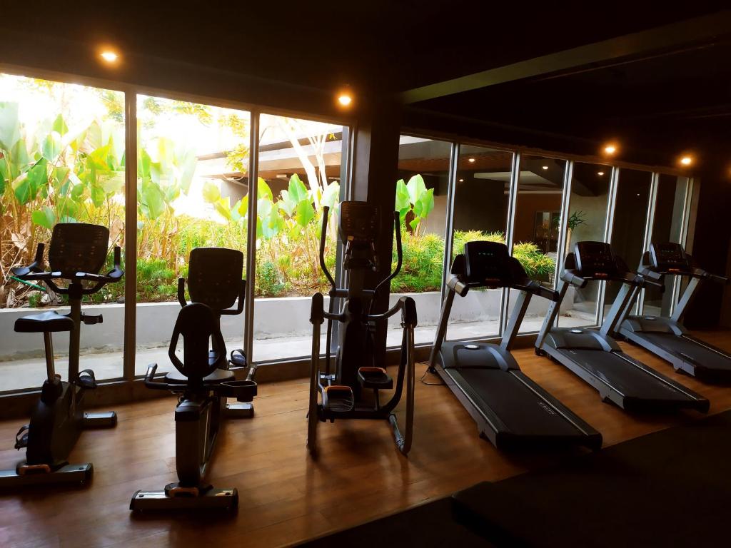 a gym with several tread machines and a window at DeAr Caspian Apartment in Surabaya