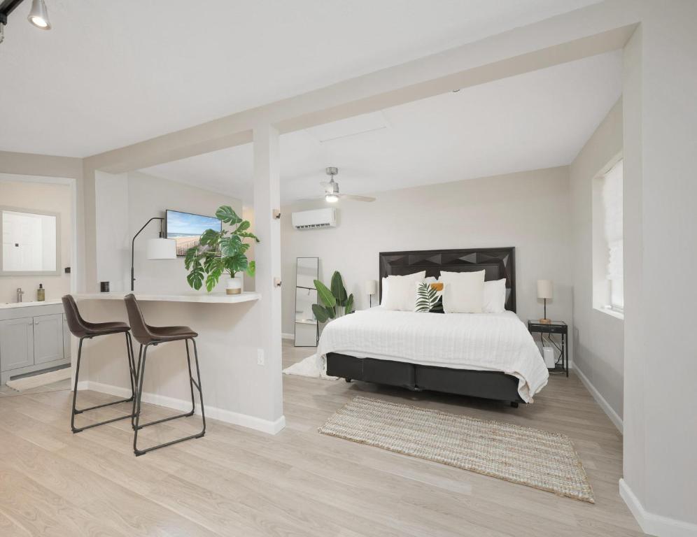 um quarto branco com uma cama, uma mesa e cadeiras em Hydrangea Cottage Unit B em Saint Augustine