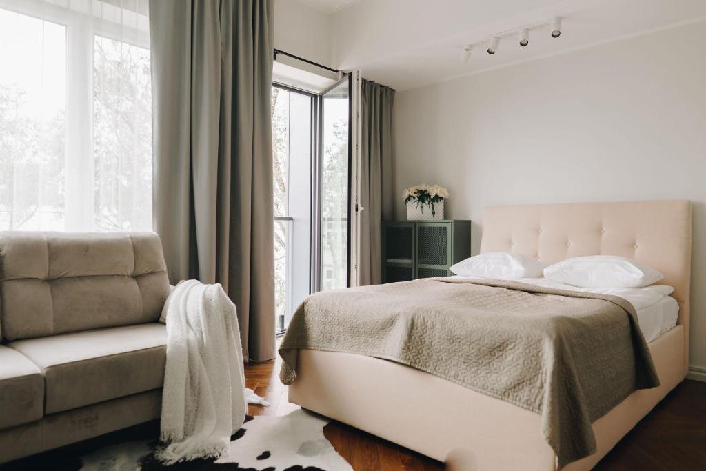 1 dormitorio con 1 cama, 1 silla y 1 ventana en Dream Stay - Stylish Studio with French Balcony, en Tallin