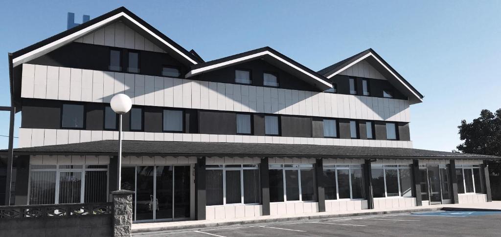 a building with a black and white at Hotel Mercedes in Camargo