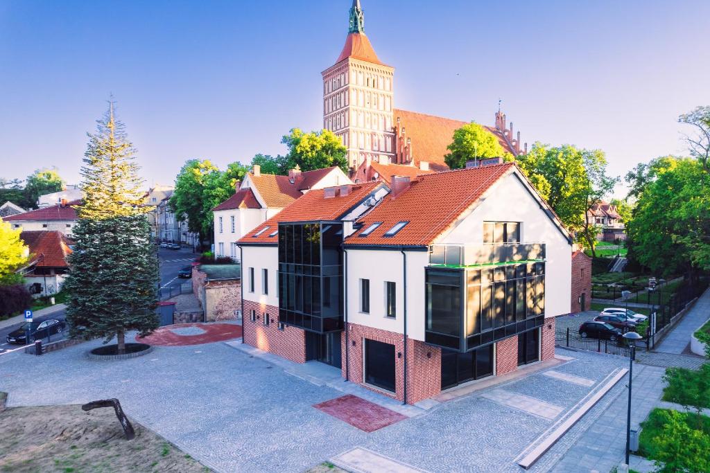 a large white house with a red roof at Warmia Apartments in Olsztyn
