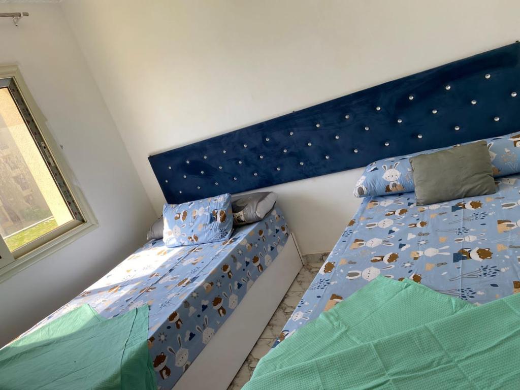 a bedroom with two twin beds with a blue headboard at مرسى مطروح in Marsa Matruh