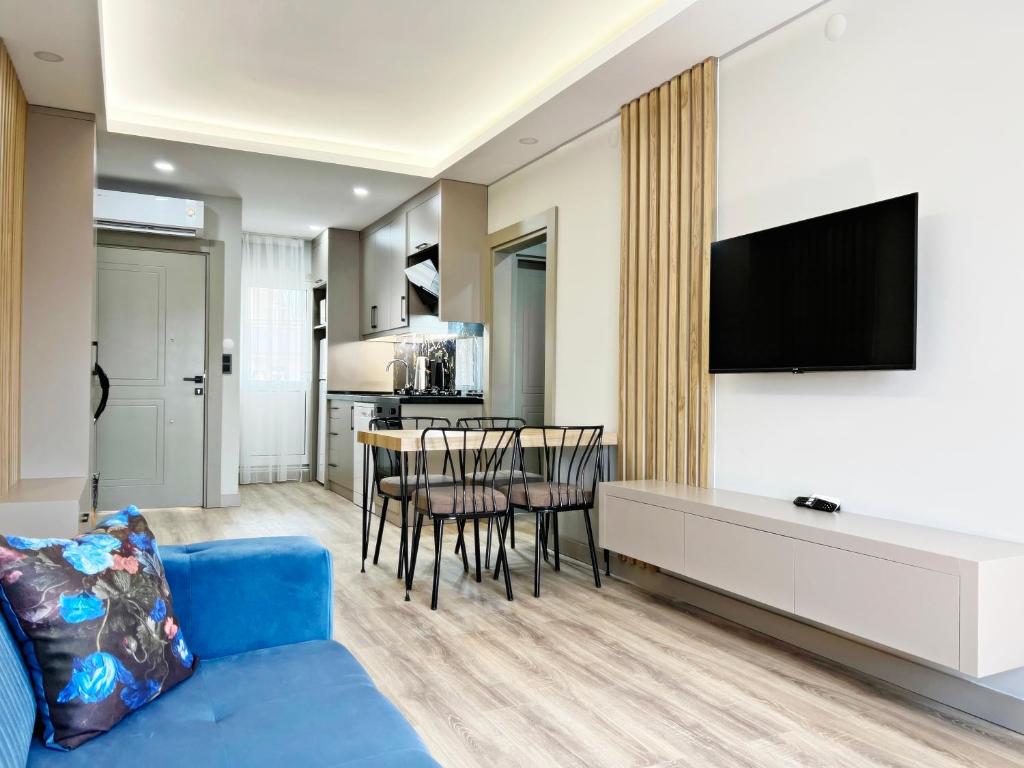 a living room with a blue couch and a table at Kemer Sunrise Suit in Kemer