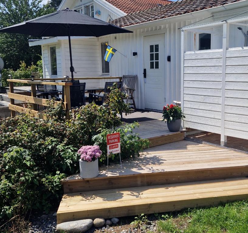 Casa con terraza de madera con sombrilla en Humlebo en Åsa