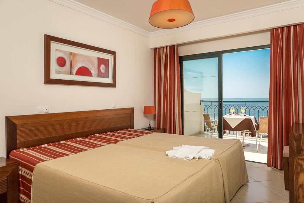 a bedroom with a bed and a view of the ocean at Cerro Mar Atlantico & Cerro Mar Garden in Albufeira